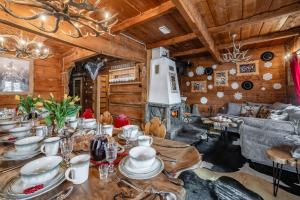 una sala da pranzo con tavolo e piatti di BAJKOWA FOLK Jacuzzi Zakopane a Murzasichle