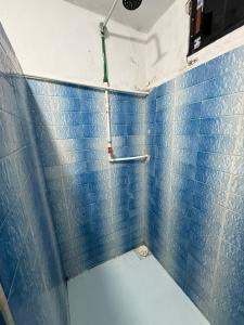 a bathroom with a blue tiled wall and a shower at CasaAZUL in Progreso