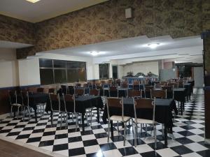 a banquet hall with tables and chairs on a checkered floor at Gutemberg Palace Hotel in Nova Serrana