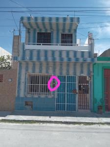 a building with a pink sign on the front of it at CasaAZUL in Progreso