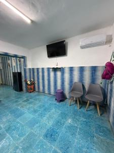 a room with two chairs and a flat screen tv at CasaAZUL in Progreso