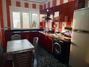 a kitchen with red and white striped walls and a refrigerator at Beach Residence, 350m de la Plage in Saïdia
