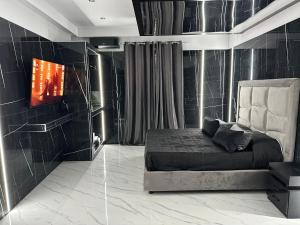 ein Schlafzimmer mit Bett und Flachbildfernseher in der Unterkunft Luxurymimi in Palermo