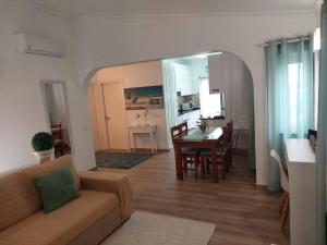 ein Wohn- und Esszimmer mit einer Couch und einem Tisch in der Unterkunft Apartment Studio Espiche near Praia da Luz in Luz + 9 Fotos
