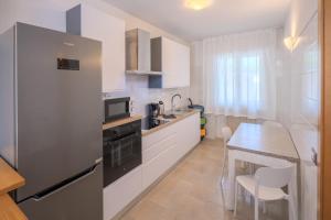 a kitchen with white cabinets and a table and a counter at Casa Lis E-Bike Apartment in Malcesine