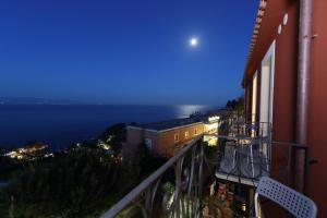 a view of the ocean from a balcony at night at Villa Astoria in Taormina