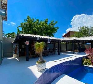 a resort with a swimming pool and a patio at Casa Alto Padrão - Condomínio Paradise Ponta da Areia in São Pedro da Aldeia