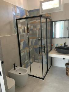 a bathroom with a shower and a toilet and a sink at Casa vacanze Tramontana Salentina in Lendinuso +11 photos