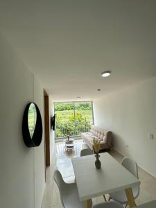 a living room with a white table and chairs at Apto con vista verde y aire acondicionado in Barranquilla