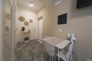a small room with a table and a television at Slow Chic Apartment Papardo in Messina