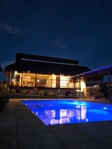 a building with a blue swimming pool at night at Lighthouse Pipa in Tibau do Sul