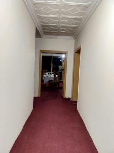 锡卡都Skardu Place Hotel & Restaurant的铺着红地毯的走廊和餐厅