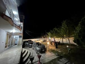 锡卡都Skardu Place Hotel & Restaurant的夜间停在大楼外的汽车