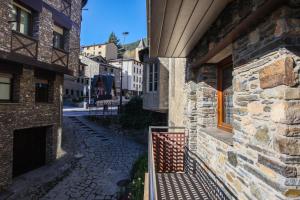 a stone building with a gate next to a street at Apartamentos Telecabine 365 in La Massana