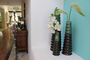 two vases with flowers in them on a wall at La Villa du Golf à Cancun Hotel Boutique in Cancún +37 photos