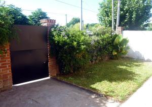 una puerta de garaje negra en un patio con arbustos en Casa Diego y Claudia, en Colonia del Sacramento