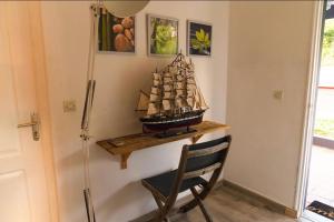 a small wooden ship on a shelf next to a chair at Domaine Yacinthe in Le Robert