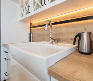 a white sink in a kitchen with a kettle at Apartament River Tower in Bydgoszcz +17 photos