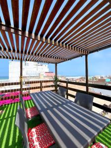 a wooden pergola with a table and chairs on a balcony at Hospedaje Casa de Playa Arica in Lurín