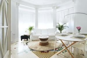 ein weißes Wohnzimmer mit einem weißen Sofa und einem Tisch in der Unterkunft Victoria Site-Luxury Center in Valencia