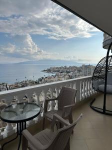 Un balcón con sillas y una mesa y vista al mar. en Tote's Sea View Apartament, en Sarandë