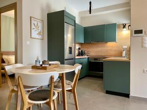 a kitchen with green cabinets and a table and chairs at Neo-Residence in Neochórion
