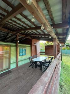 a patio with a table and chairs on a deck at Domki Olia in Choczewo +9 photos