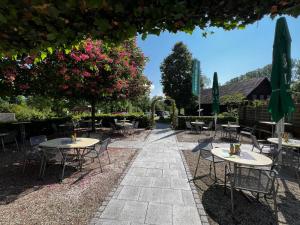 a patio with tables and chairs and a tree with pink flowers at Groasmückle Apartment in Tauberbischofsheim