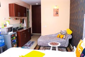 a living room with a couch and a kitchen at Budget bliss1 bnb Ruaka in Ruaka