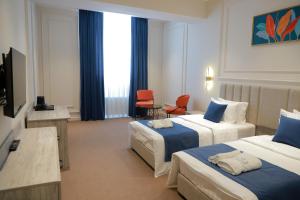 a hotel room with two beds and a television at Emily Grand Palace in Samarkand +35 photos