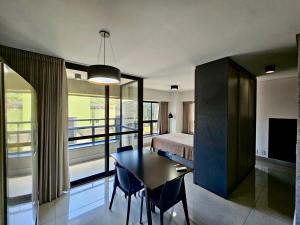 a room with a bed and a table and a bedroom at Studio Compacto com Design Clean no Vertigo in Campo Grande