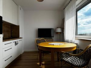 a kitchen with a table and chairs and a television at Apartament606 in Puszczykowo