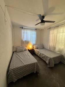 a bedroom with two beds and a ceiling fan at Residencia en Guadalupe in Monterrey