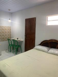 ベレンにあるCasa Marajó no Centro de Belém COP30のベッドとテーブルと椅子のある寝室