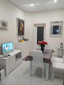 a white living room with a table and a television at Room Boutique Don Antonio in Córdoba