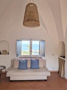 a living room with a couch and a window at Dammusi Futura in Pantelleria
