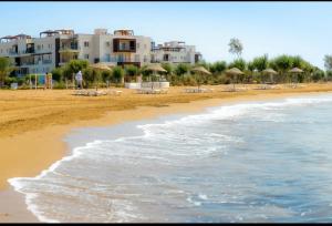 ein Strand mit Stühlen und Sonnenschirmen und das Meer in der Unterkunft Thalassa Beach Resort - 108 in Vokolidha