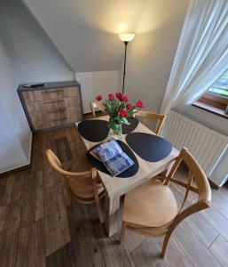 a dining room table with a vase of flowers on it at U Suchowiana - cisza i spokój z widokiem na Tatry in Zakopane