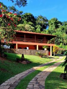 a house with a brick path in front of it at casa de campo bem na natureza in Araras Petropolis