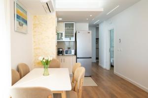 a kitchen and dining room with a white table and chairs at The blue pearl apartment 2 in Durrës
