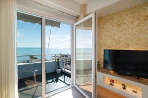a living room with a tv and a large window at The blue pearl apartment 2 in Durrës