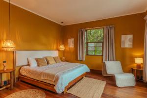 a bedroom with a bed and a chair and a window at awā San José in San José