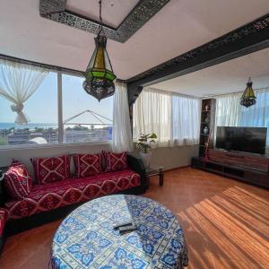 salon z czerwoną kanapą i telewizorem w obiekcie Family-Friendly Villa with Private Pool & Rooftop Sunset Views, 5min to Taghazout w mieście Agadir nʼ Aït Sa