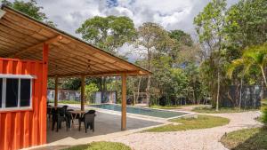 a pavilion with a table and chairs next to a pool at Villa Ecco Cubo in Alto Paraíso de Goiás