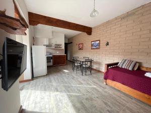 Departamento Cafayate في كفايات: غرفة بسرير ومطبخ مع طاولة +25 صورة