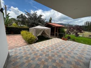 une tente blanche en face d'un bâtiment dans l'établissement Cabaña Villa Luz, à Paipa