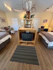 a room with two beds and a tv on a table at Burns Lake Bed and Breakfast in Burns Lake