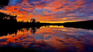 a sunset on a lake with clouds in the water at Burns Lake Bed and Breakfast in Burns Lake