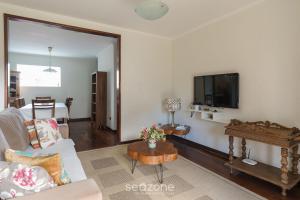 a living room with a couch and a tv at Casa espaçosa c/lareira em Campos do Jordão RAS175 in Campos do Jordão