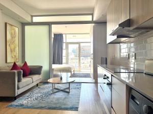 a kitchen and living room with a couch and a table at City view studio apartment CBD in Cape Town